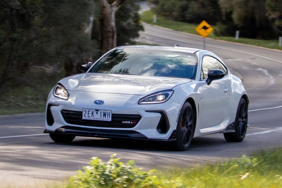 A white Subaru BRZ tS coupe driving on a country road in Australia, seen from the front three-quarter angle