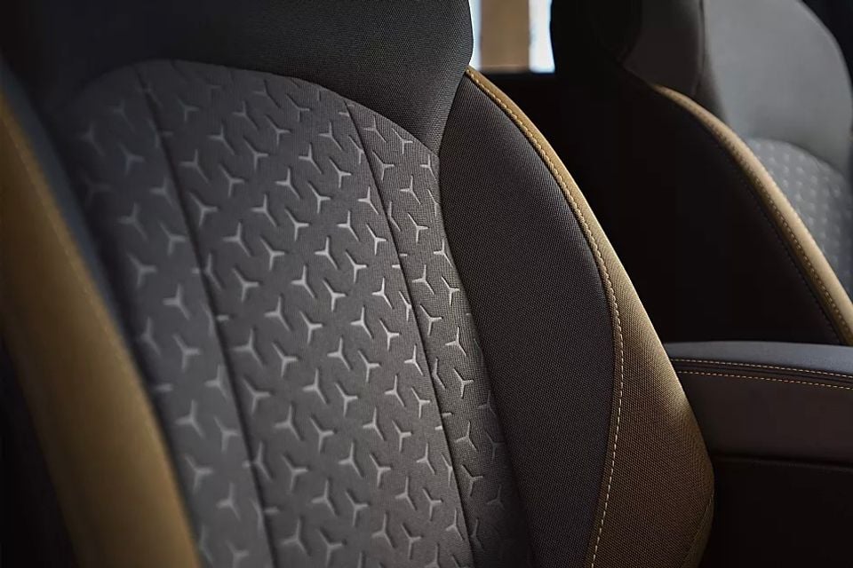 Close-up of a car seat showing textured grey fabric with a star pattern and tan leather-style bolsters with contrast stitching, inside the 2026 Subaru Crosstrek Sport Special Edition.