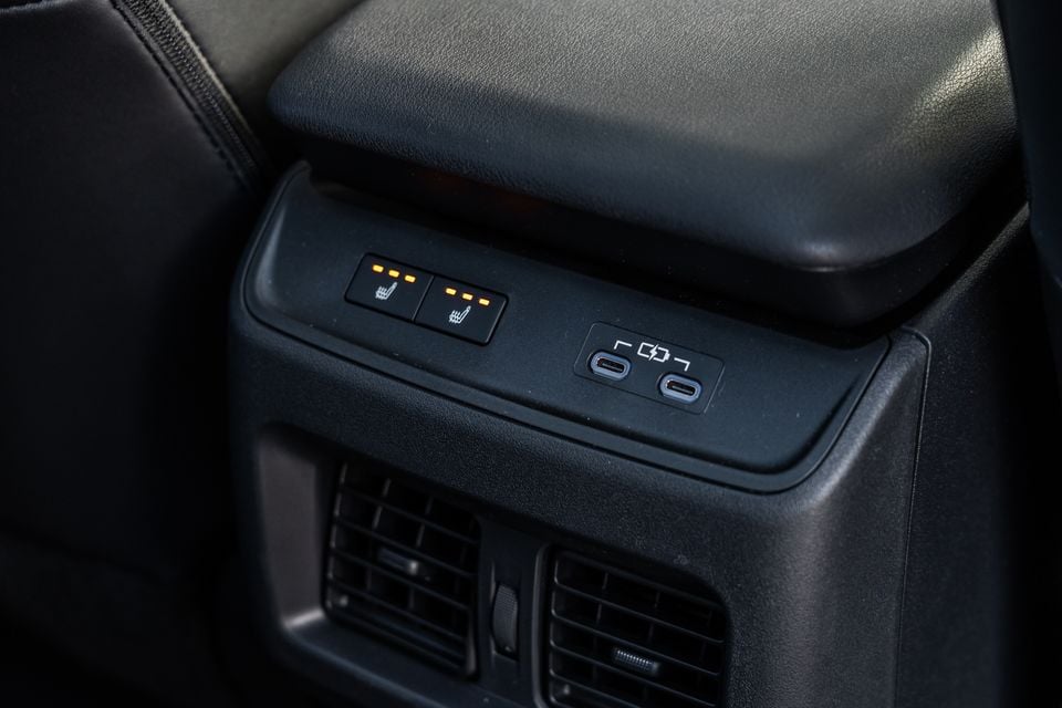 Rear centre console of a Subaru showing heated seat buttons illuminated in amber and two USB-C charging ports, with air vents below
