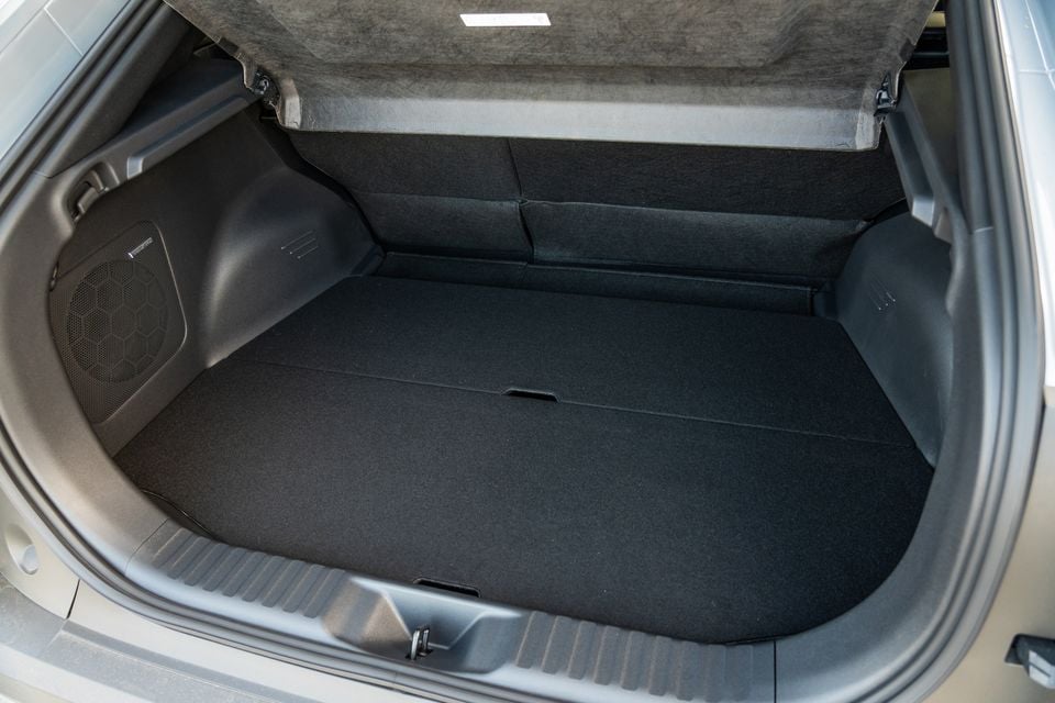 The empty boot of a 2026 Subaru Outback, showing a flat carpeted load floor with a subwoofer speaker on the left side wall