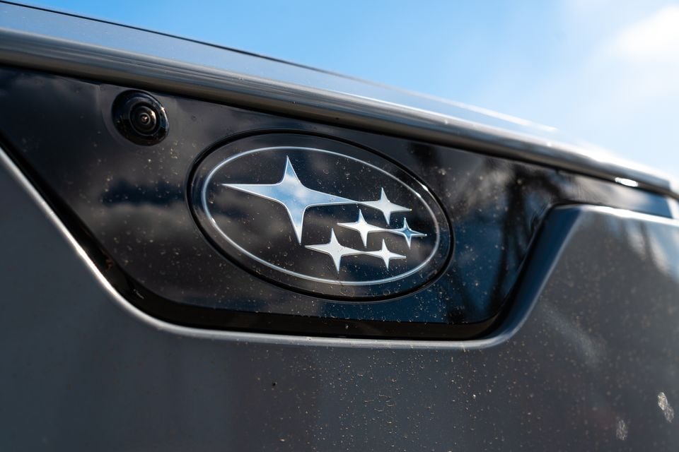 Close-up of the Subaru star badge on the rear of a dusty grey Subaru vehicle