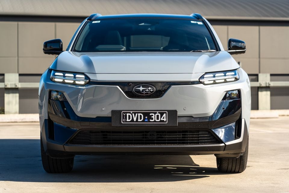 A silver Subaru Uncharted SUV seen from the front, parked on a concrete surface in front of a building