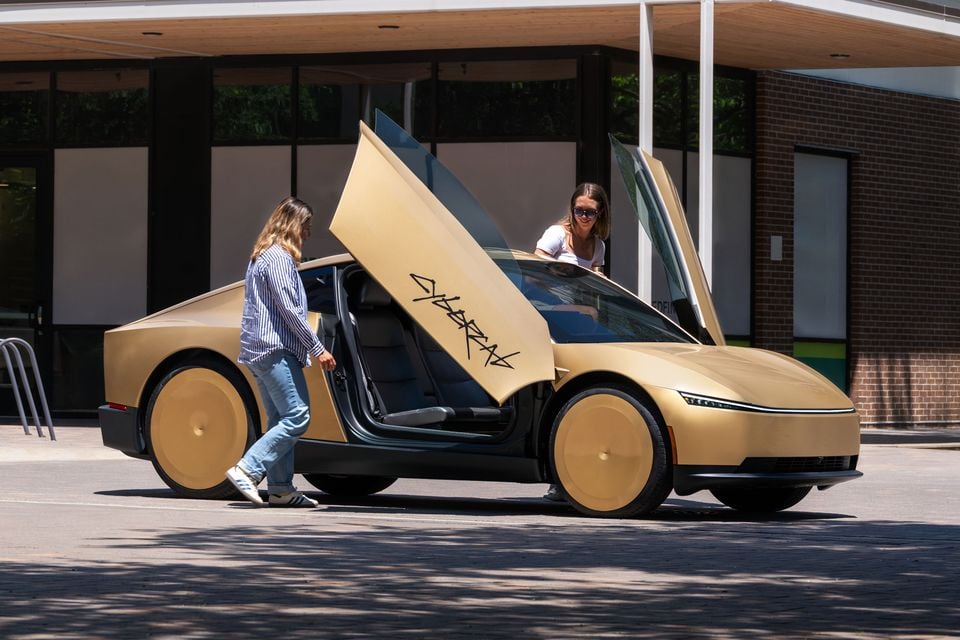 Gold Tesla Cybercab with its doors raised in an existing Tesla publicity image; not an Australian robotaxi service.