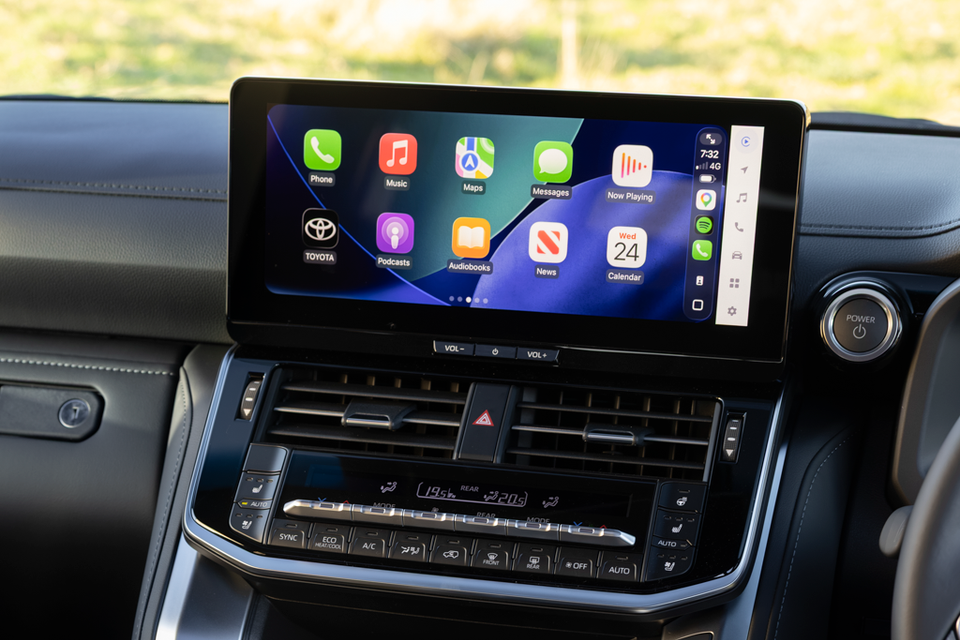 Toyota Land Cruiser 300 centre touchscreen displaying Apple CarPlay, with climate control buttons below