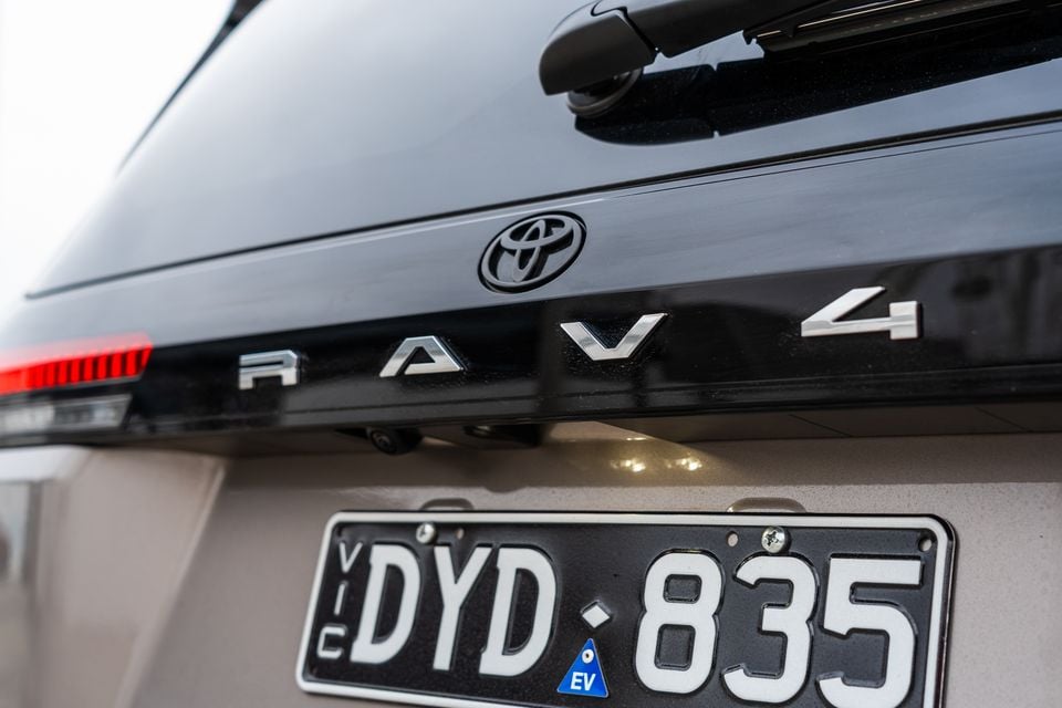 Close-up of the rear badge and "RAV4" lettering on a black 2026 Toyota RAV4, with a Victorian number plate below