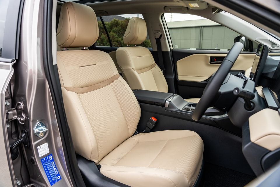 The beige leather front seats of a 2026 Toyota RAV4 Cruiser, viewed through the open driver's door