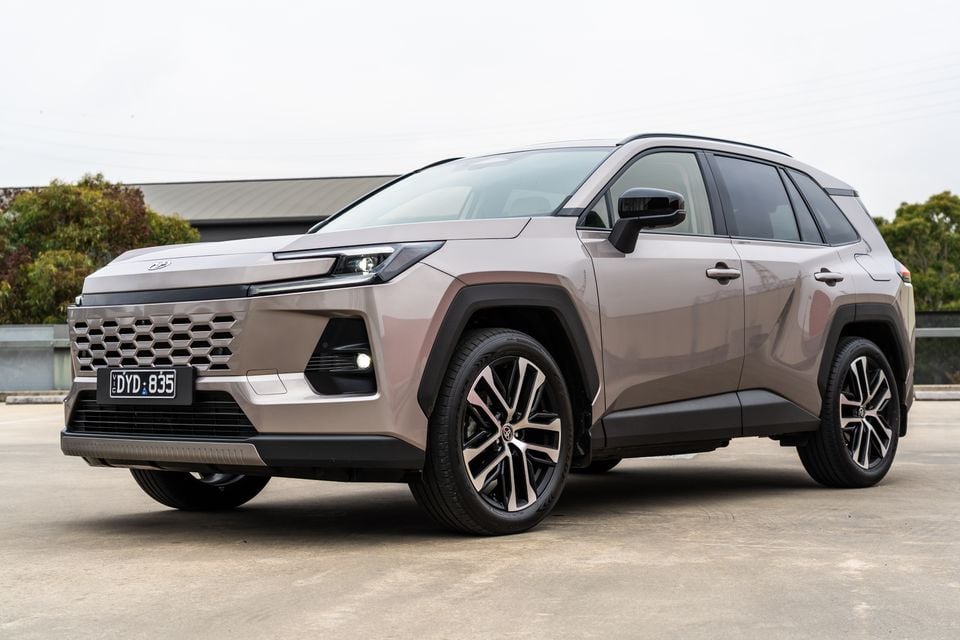 A bronze-coloured 2026 Toyota RAV4 Cruiser SUV photographed from the front quarter in a car park