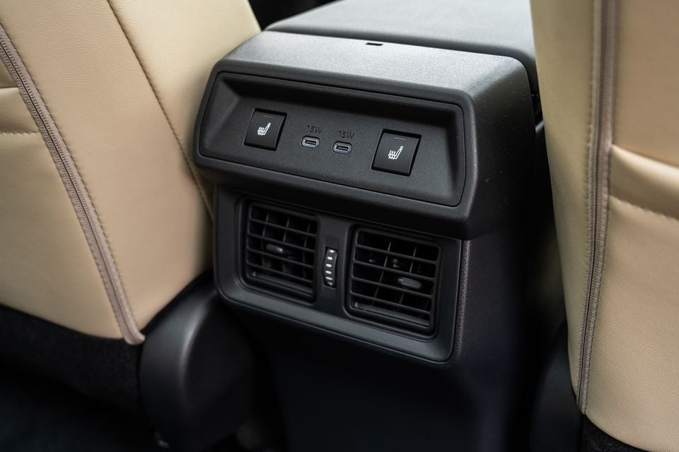 Close-up of the rear centre console in a 2026 Toyota RAV4 Cruiser, showing heated seat buttons, two USB-C ports and rear air vents between tan leather seats.