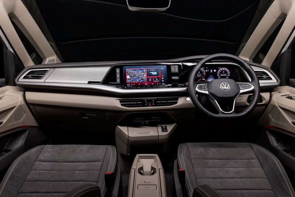 Interior of a 2026 Volkswagen Multivan Edition showing the dashboard, touchscreen infotainment system, digital instrument cluster, steering wheel, and front seats