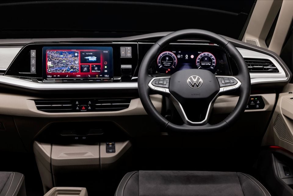 Interior view of a 2026 Volkswagen Multivan showing the dashboard, steering wheel, digital instrument cluster and touchscreen infotainment system with navigation and Apple CarPlay displayed
