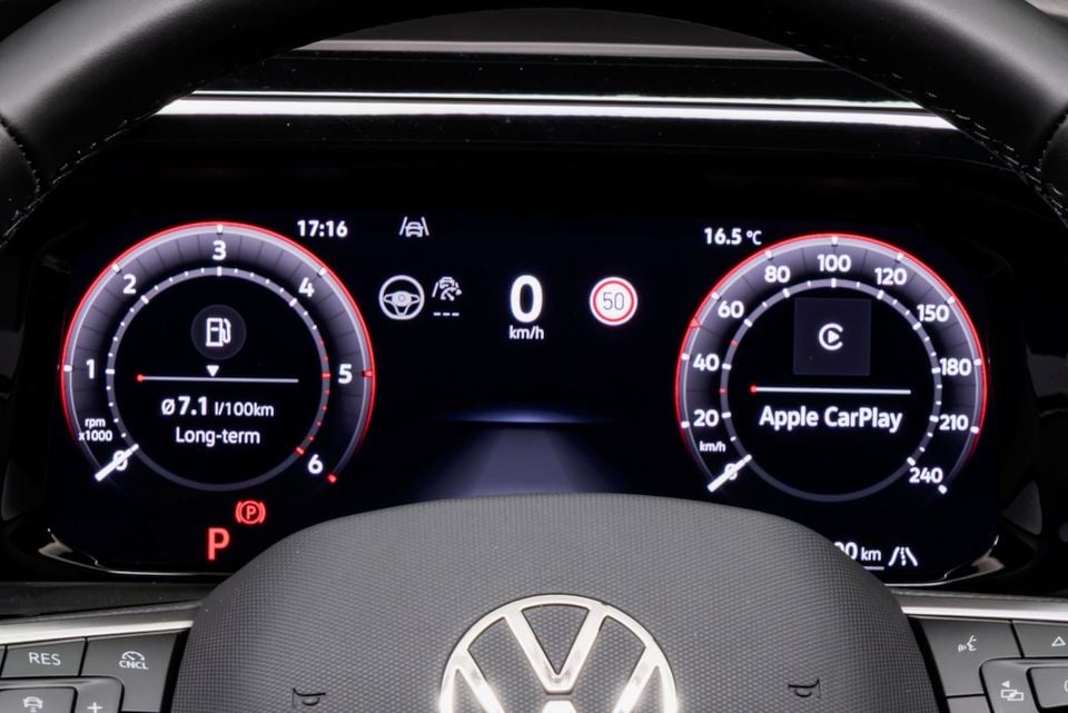 Volkswagen digital instrument cluster showing speedometer, tachometer, Apple CarPlay notification, fuel consumption reading of 7.1L/100km, and a 50km/h speed sign alert