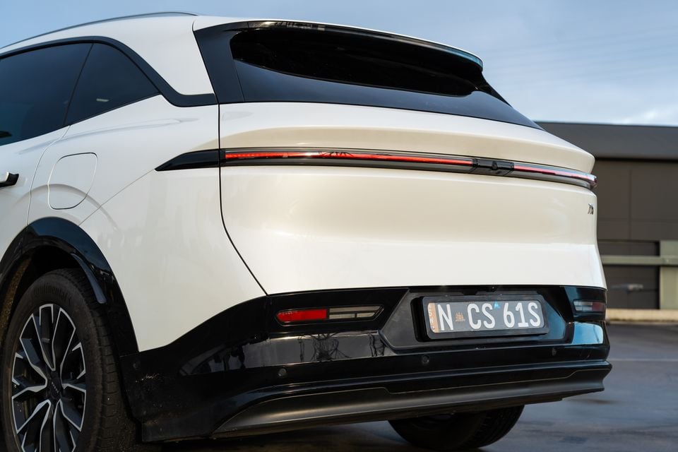 Rear view of a white 2026 Zeekr 7X SUV showing its full-width tail light bar and NSW number plate, seen from a rear three-quarter angle in a car park.