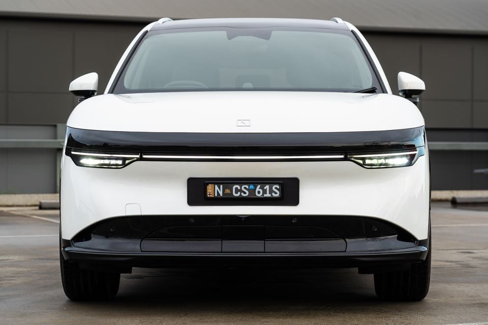 A white 2026 Zeekr 7X SUV seen from the front, parked in a car park with its LED headlights on