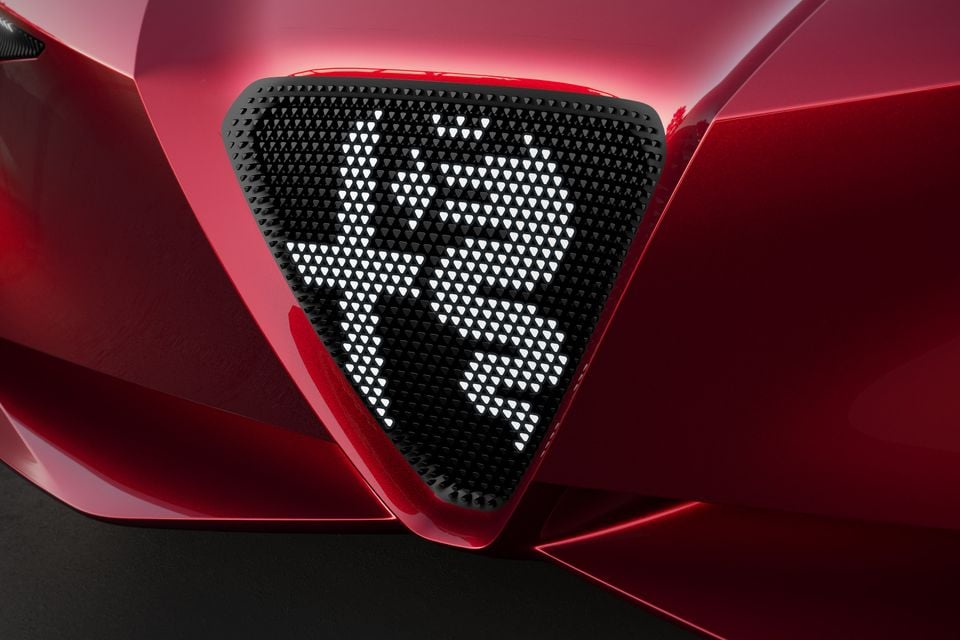 Close-up of the red 2026 Alfa Romeo Cuorerosso's triangular grille, with a perforated pattern illuminated to form the number 33