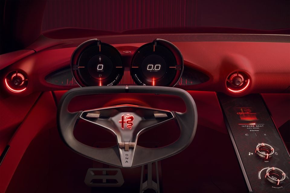 Red cabin of the 2026 Alfa Romeo Cuorerosso concept with a yoke-style steering wheel, twin circular digital gauges and a centre console touchscreen