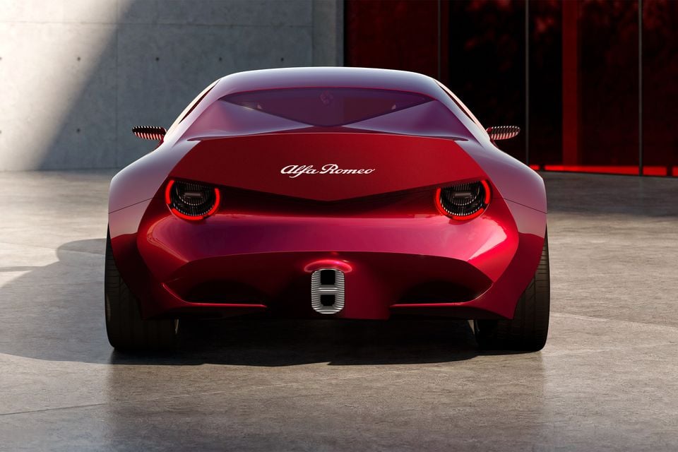 A red 2026 Alfa Romeo Cuorerosso concept coupe seen from directly behind, showing its round tail-lights and Alfa Romeo script