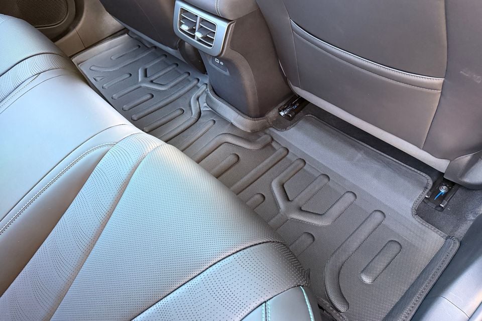 A rugged rubber floor mat covers the rear footwell of a 2026 BYD Seal 6 Touring, seen from above alongside the rear air vents and seats.