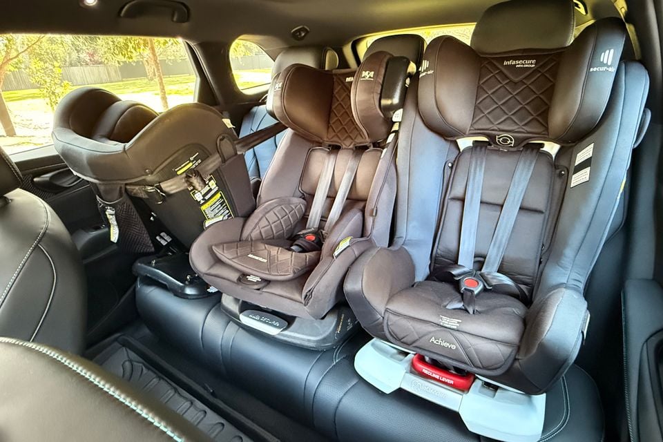 Three child car seats, including a rear-facing baby capsule, installed across the second-row seats of a 2026 BYD Seal 6 Touring