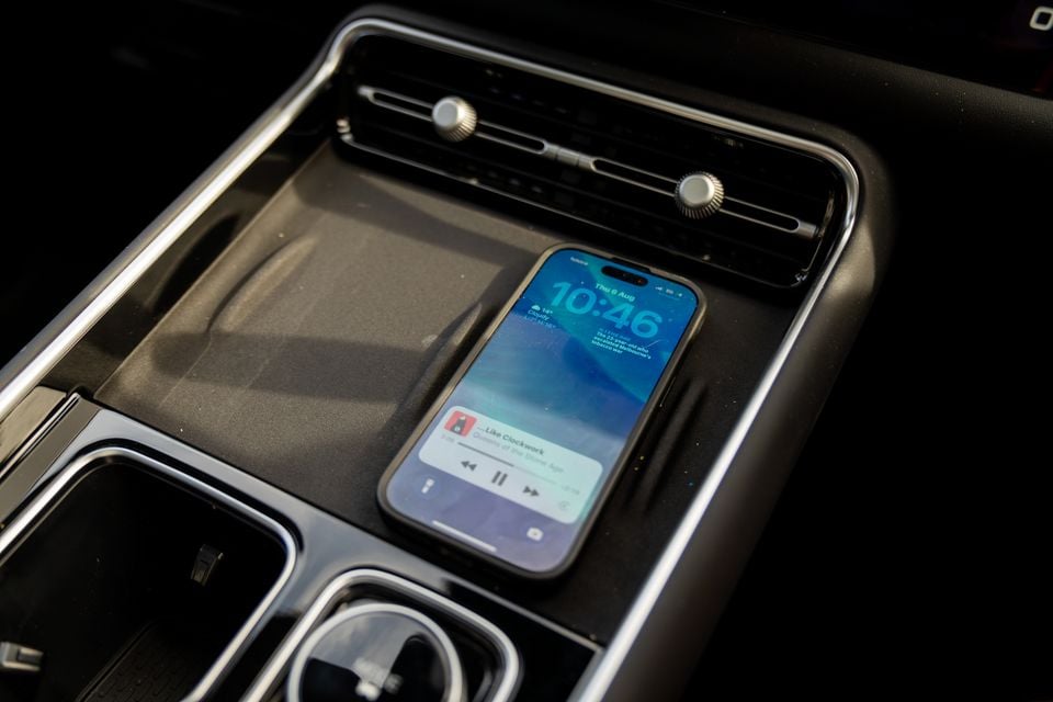 A smartphone placed on the wireless charging pad in the centre console of a Chery Tiggo 9