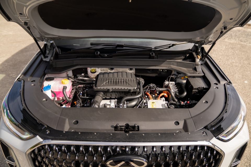 Engine bay of a 2026 Chery Tiggo 9 with the bonnet open, showing the hybrid powertrain components including orange high-voltage cables