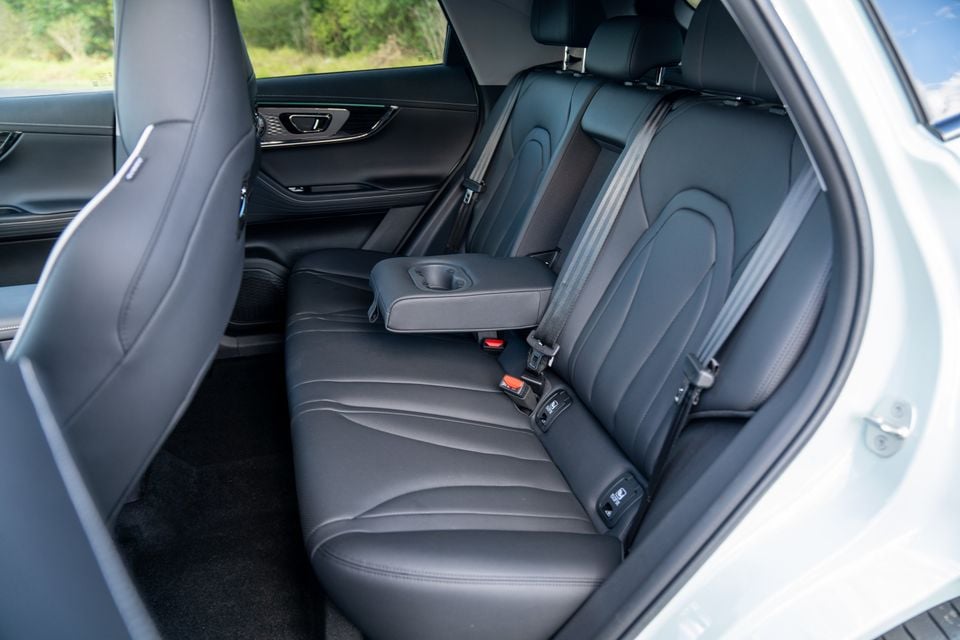 Rear interior of a Chery E5 showing dark leather rear seats with a fold-down centre armrest and cup holder