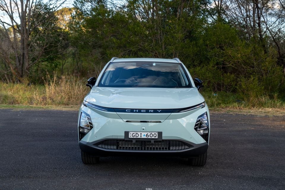 A white Chery E5 SUV seen from the front, parked on a road surrounded by bushland