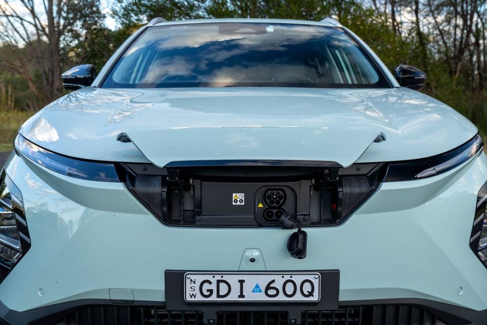 Front view of a light green Chery E5 electric SUV with the charge port door open, showing the EV charging socket, with a NSW number plate visible