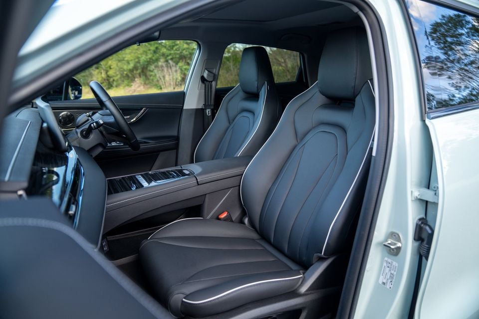 Interior view of a 2026 Chery E5-6 showing dark leather front seats, centre console, and steering wheel