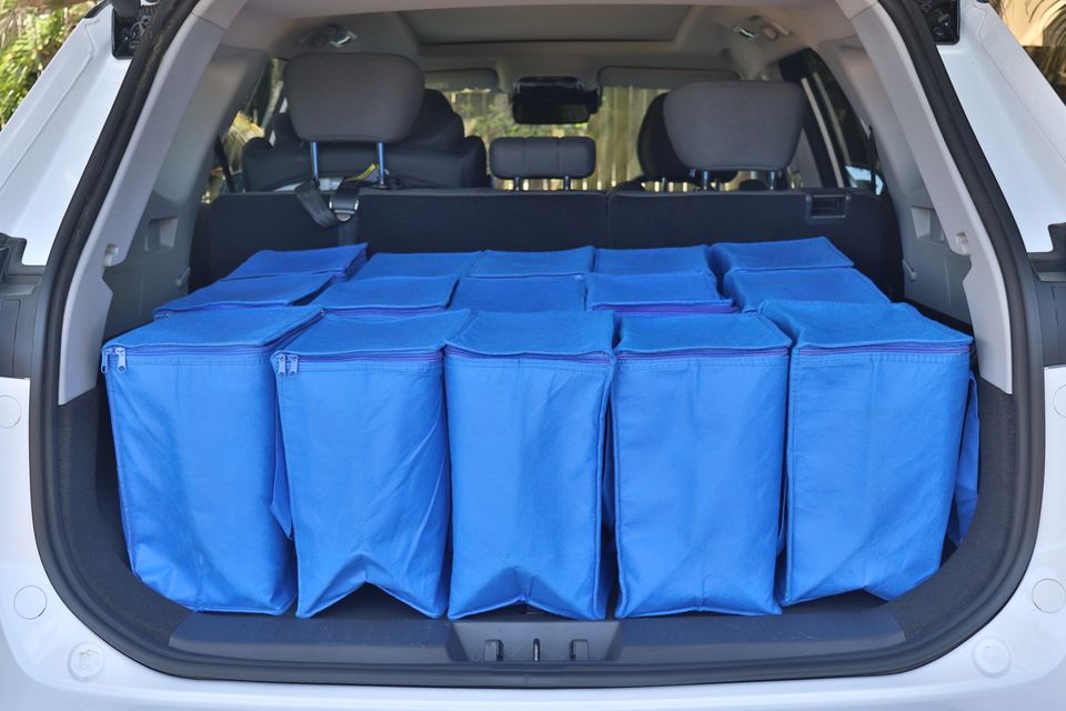 The boot of a white 2026 Chery Tiggo 8 SUV packed full of blue reusable shopping bags.