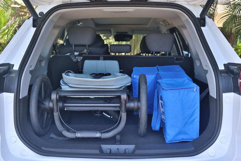 The boot of a white 2026 Chery Tiggo 8 SUV loaded with a folded stroller and blue storage bags.