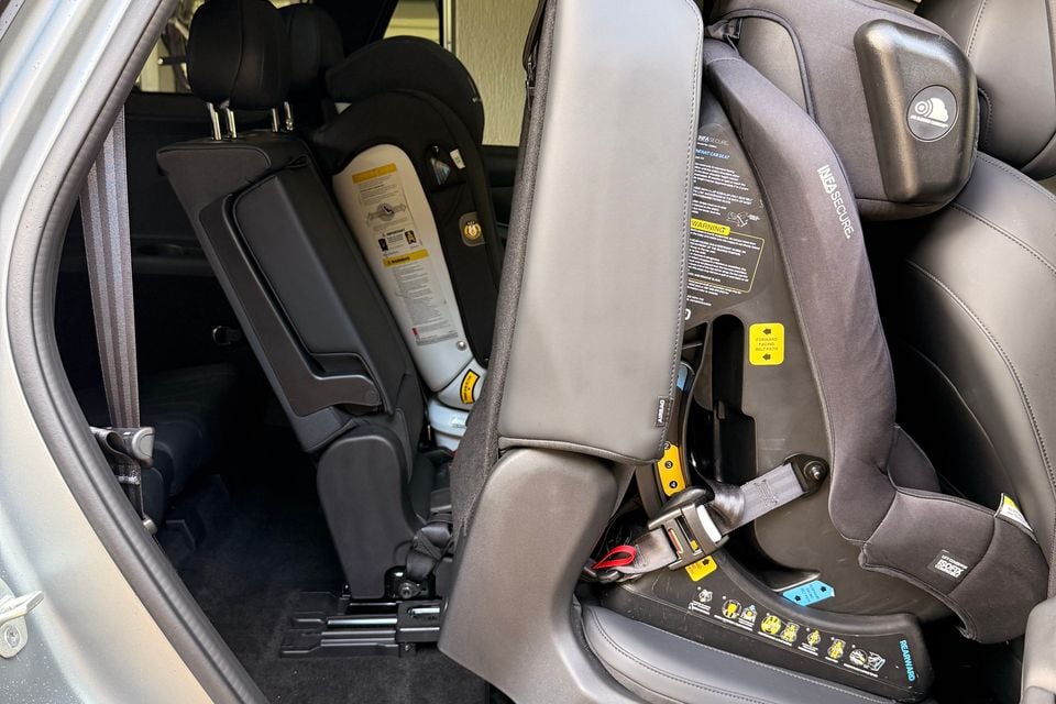 A rear-facing child car seat installed in the second row of a 2026 Chery Tiggo 9 SUV, seen through the open rear door.