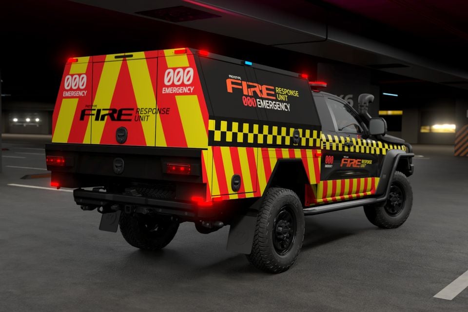 A 2026 Ford Ranger Super Duty prototype fire response unit with red and yellow emergency livery, seen from the rear three-quarter angle in a car park