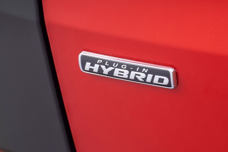 A Plug-In Hybrid badge on the red body panel of a Ford Tourneo Custom
