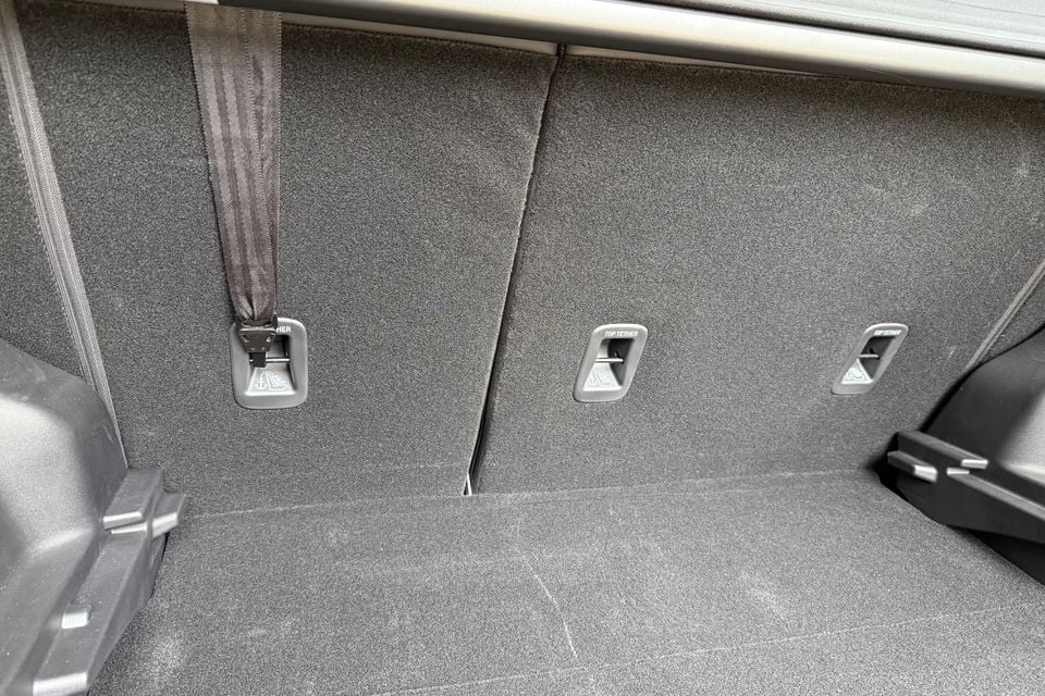 Close-up of the top tether anchor points in the folded rear seats of a 2026 Geely Starray