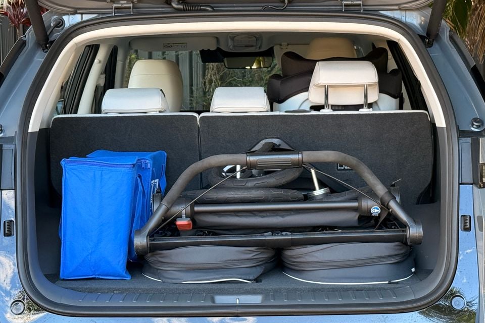 Boot of a blue Hyundai Elexio SUV loaded with a folded pram and a blue bag, viewed from the rear with the tailgate open