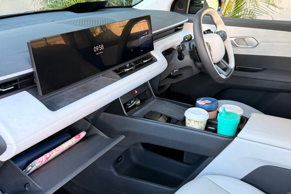 Interior of the 2026 Hyundai Elexio showing the wide dual-screen infotainment display, floating centre console with cup holders, open storage compartment and steering wheel