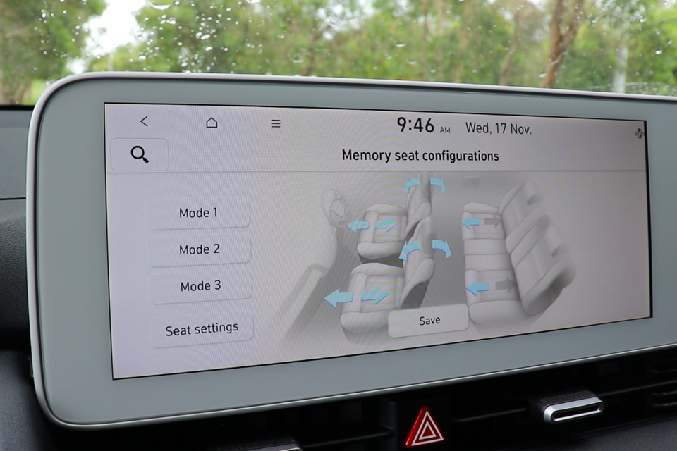A car infotainment touchscreen showing the memory seat configurations menu with three mode options and a seat diagram with adjustment arrows