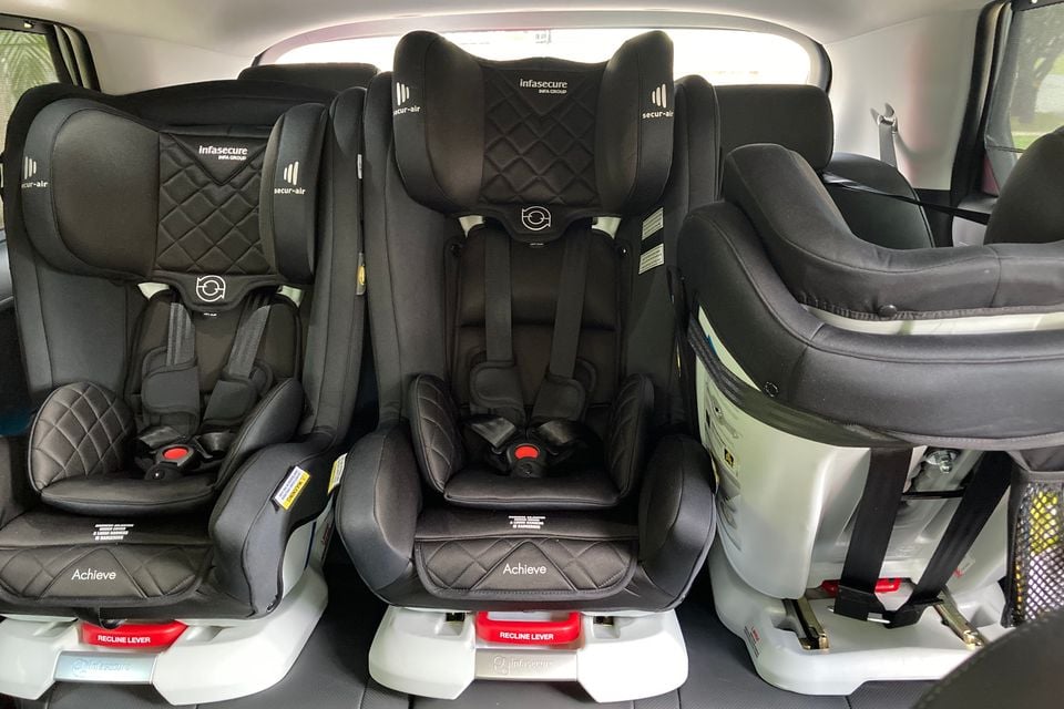 Three Infasecure Achieve child car seats fitted side by side across the rear seat row of a vehicle