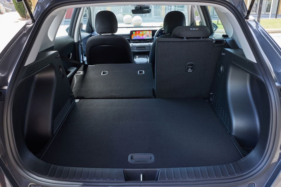 The boot of a 2026 Hyundai Kona Electric shown with the rear seats folded down to extend cargo space