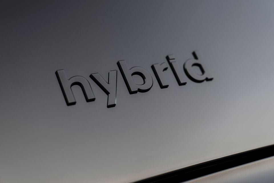Close-up of a 'hybrid' badge on the body panel of a 2026 Hyundai Palisade