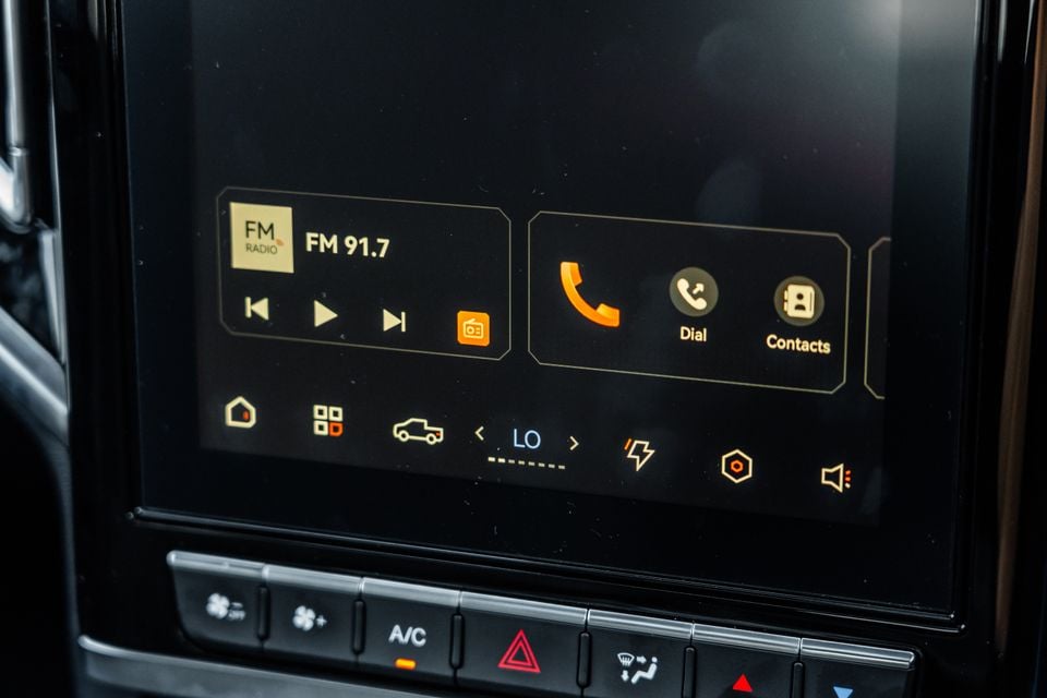 Close-up of a JAC Hunter PHEV infotainment touchscreen showing FM radio and phone controls, with climate control buttons below