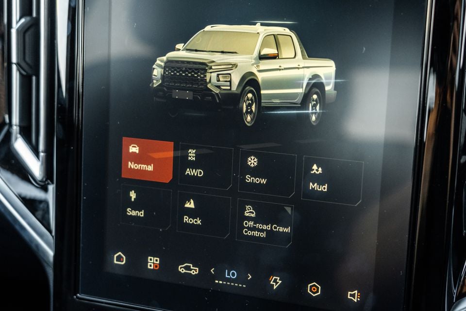 A touchscreen infotainment display in a JAC Hunter PHEV ute showing drive mode options including Normal, AWD, Snow, Mud, Sand, Rock, and Off-road Crawl Control