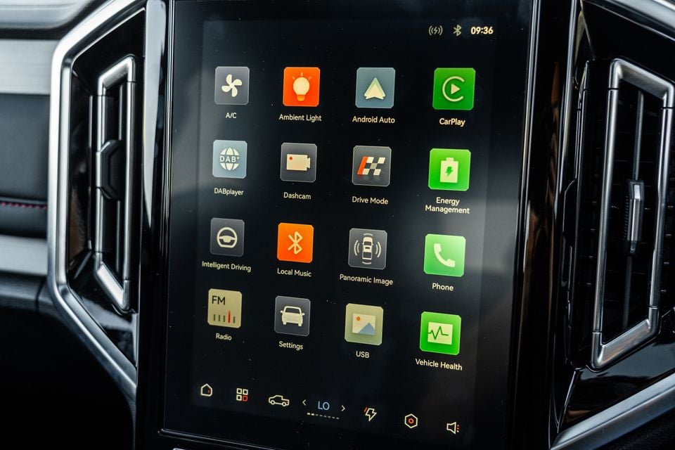 The touchscreen infotainment display of a 2026 JAC Hunter PHEV showing the app menu with icons including Android Auto, CarPlay, DAB radio, dashcam, drive mode, energy management, and vehicle health.