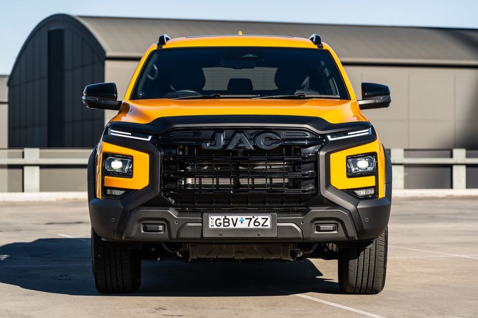Front view of a yellow 2026 JAC Hunter PHEV ute parked in an open area, showing its bold black grille and square headlight surrounds