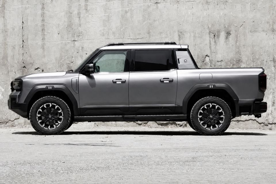A grey 2026 Jetour J700 dual-cab ute seen from the side, parked against a concrete wall