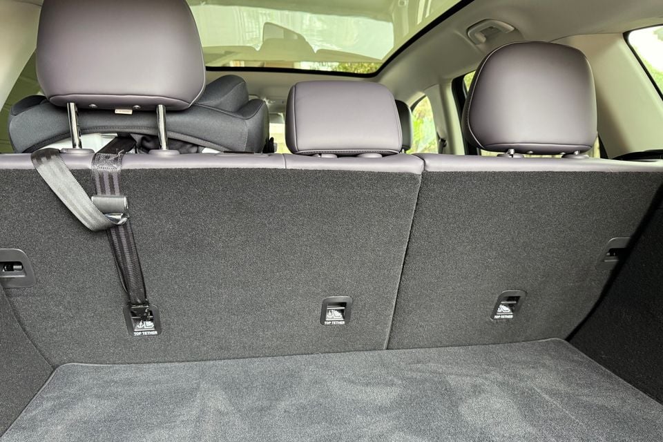 Boot of the 2026 Leapmotor C10 showing the carpeted load floor, rear seatbacks with three top tether points and a child seat installed