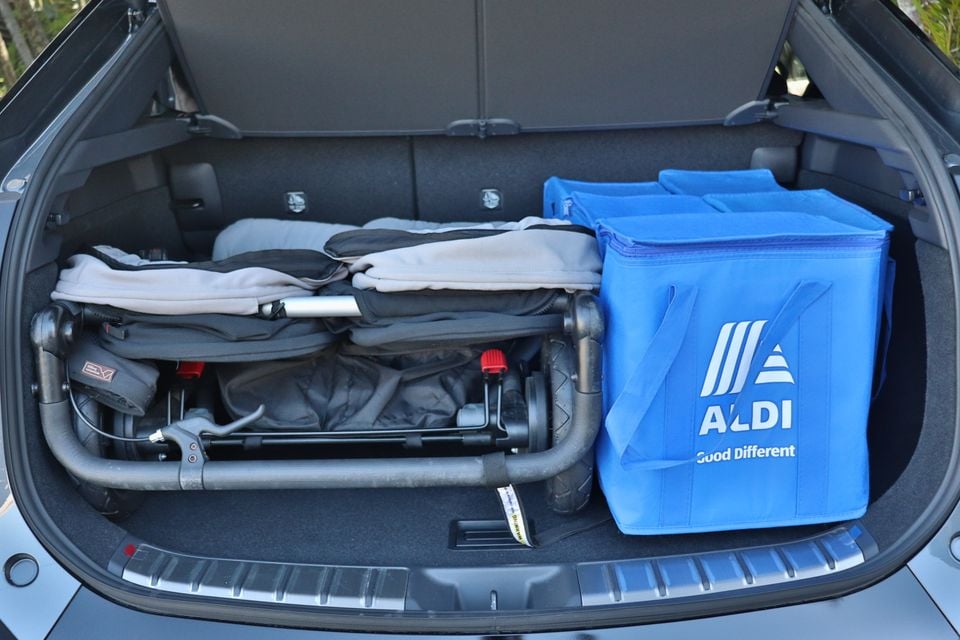 The boot of a Lexus RZ loaded with a folded pram and an Aldi insulated cooler bag, showing available cargo space.