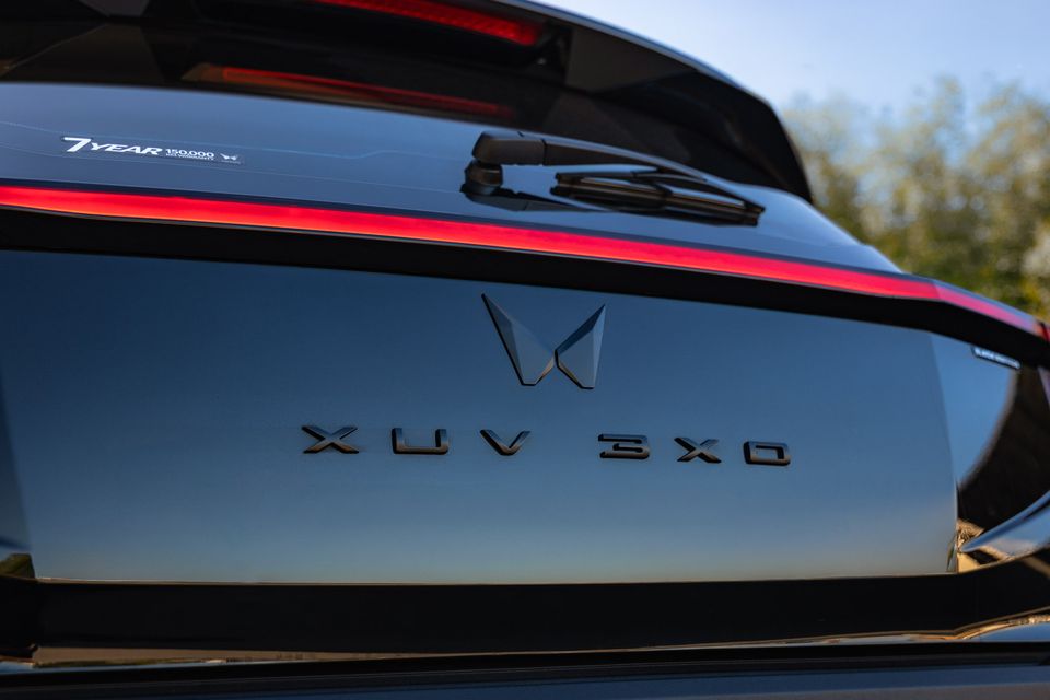 Close-up of the rear tailgate of a Mahindra XUV 3XO Black Edition, showing the model badge and brand logo with a red light bar accent