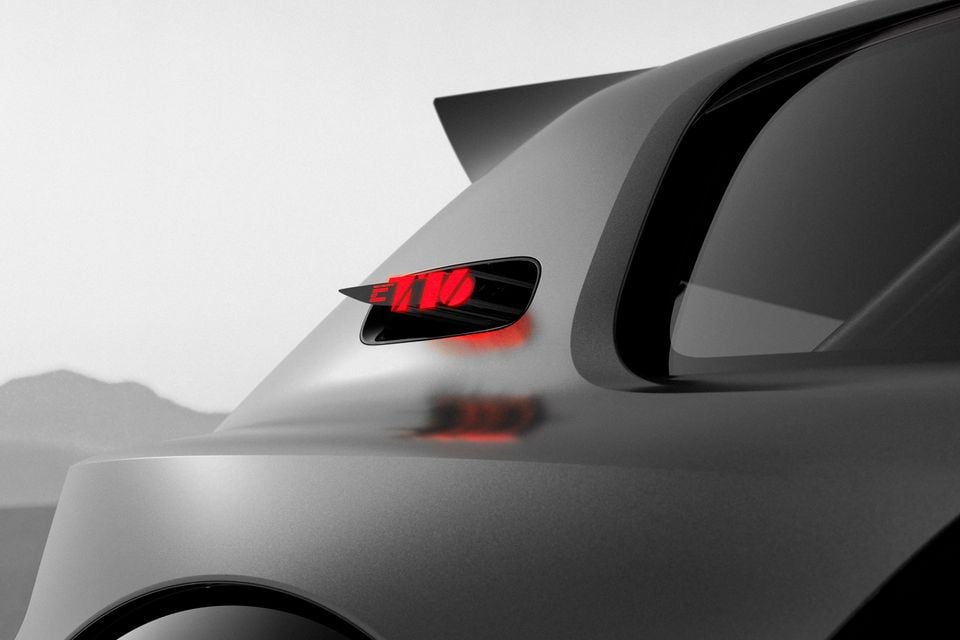 Close-up of the rear haunch of the 2026 Peugeot E-T16 concept, showing an illuminated red E-T16 logo in a side vent and a roof spoiler