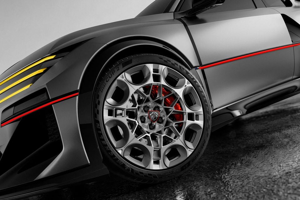 Close-up of the 2026 Peugeot E-T16 concept's front wheel, showing a sculpted alloy rim, red brake caliper, Michelin tyre and red body striping